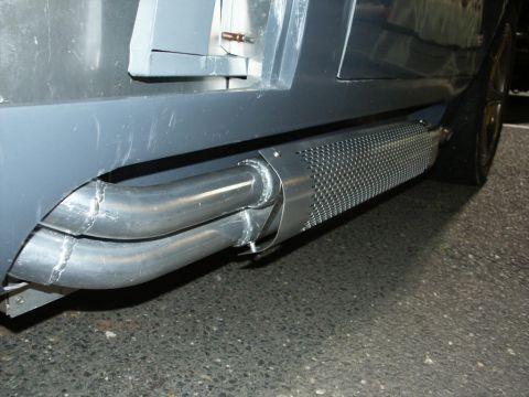 2001 Mercury Grand Marquis - Dual exhaust pipes with a perforated heat shield are visible on the side of a vehicle.