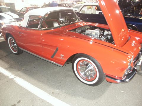 2001 Mercury Grand Marquis - Red 1961 Chevrolet Corvette convertible at a car show, engine exposed.