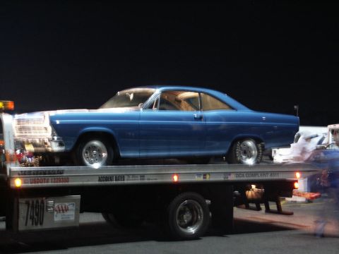 2001 Mercury Grand Marquis - A blue 1966 Ford Fairlane coupe is being transported on a tow truck at night.