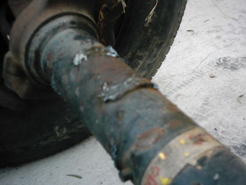 1978 Ford Bronco - Close-up of a rusty axle tube showing welds and a tire in the background. The Supermotors.net logo is visible.