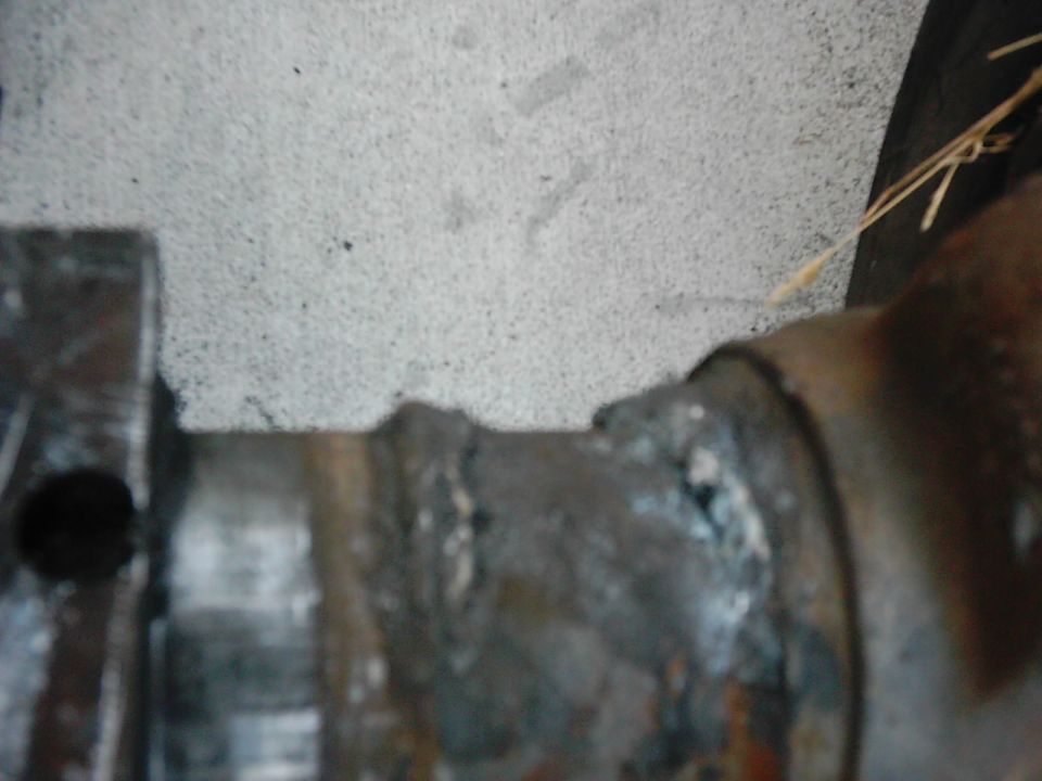 close-up of a heavily rusted metal component with a black circular hole on the left