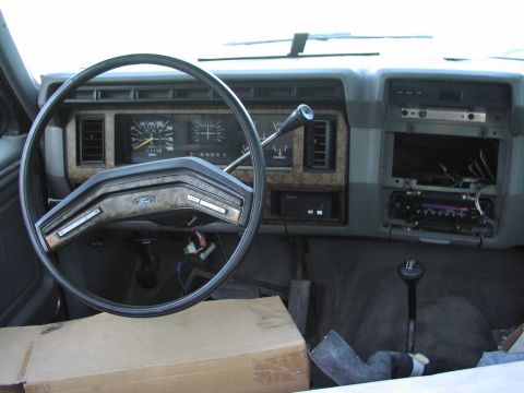 1983 Ford F-250 - Dashboard and interior of a truck, showing the steering wheel, gauges, and a disassembled radio area.