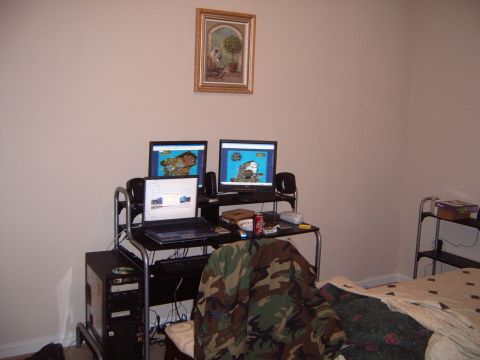 1988 Ford Bronco - A room interior a computer workstation with multiple screens and a bed in the background.