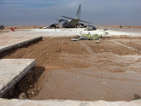 1988 Ford Bronco - Airplane wreckage on an airfield, with a large section of the runway broken.
