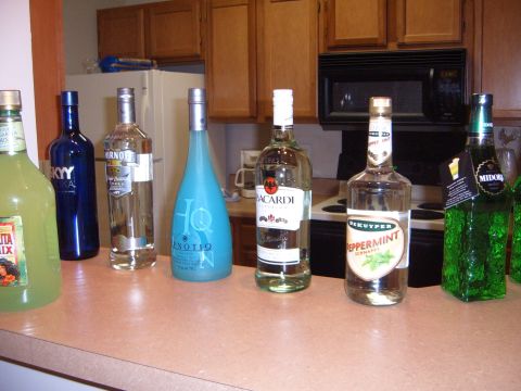 1988 Ford Bronco - A collection of assorted liquor bottles are lined up on a kitchen counter, with cabinets and appliances in the background.