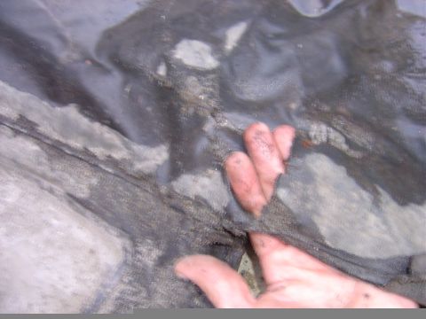 1987 Suzuki Samurai - A hand is shown touching a dirty, worn piece of fabric, possibly a car cover or upholstery.