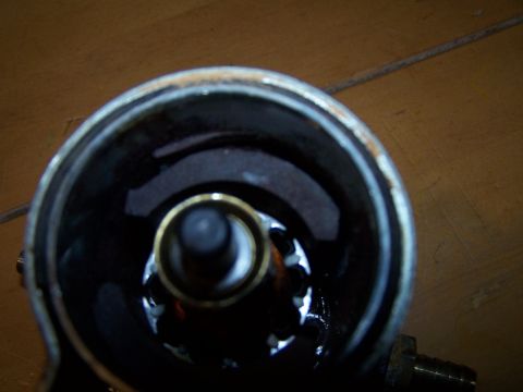 1979 Ford F-150 - Close-up view inside an oil filter housing, revealing a brass fitting and dark fluid residue.