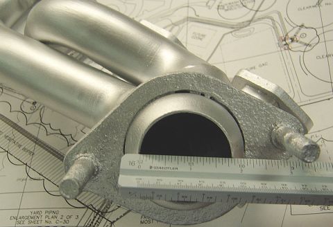 1986 Ford Bronco - A ruler is placed against an exhaust manifold, with technical drawings visible in the background.
