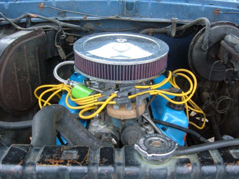 1979 Ford Bronco - Close-up of an engine bay with prominent blue valve covers and yellow spark plug wires.