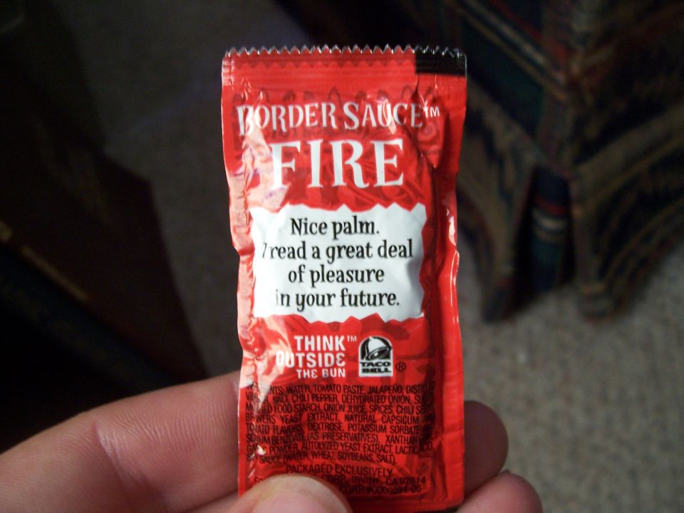 Taco Bell Fire Sauce packet with text about palm reading and ingredients