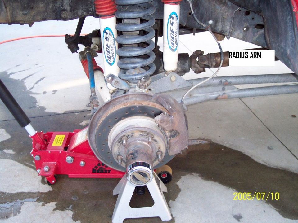 Front suspension with radius arm labeled, supported by jack stands