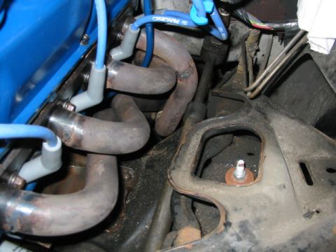 1985 Ford Crown Victoria LTD - Close-up view of an engine's exhaust manifold and blue spark plug wires, with visible text from Supermotors.net.