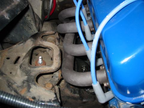 1985 Ford Crown Victoria LTD - Close-up view of an engine's exhaust manifold and spark plug wires.