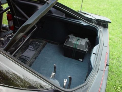 1992 Ford Probe - The trunk of a car is open, revealing a battery box and a fire extinguisher, with a roll cage visible.