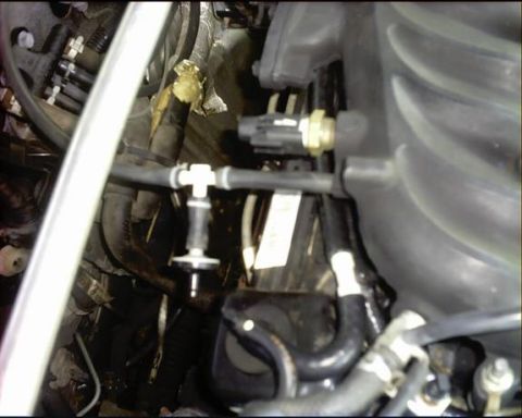1992 Ford Probe - This image shows various engine components, including hoses and a sensor, within the engine bay of a vehicle.