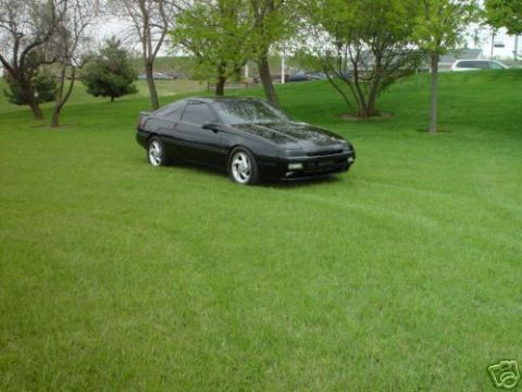 1992 Ford Probe - This 1992 Ford Probe is parked on a grassy area with trees and a cloudy sky.