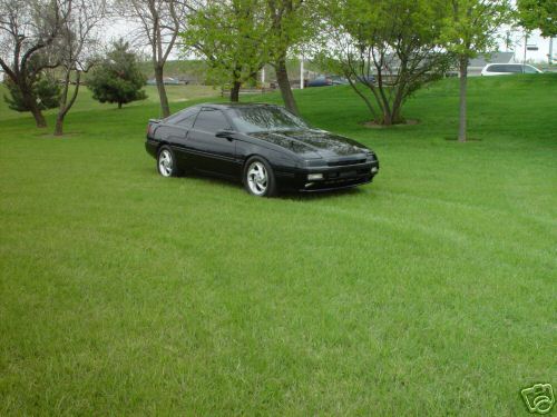 1992 Ford Probe parked on a grassy lawn with trees in the background