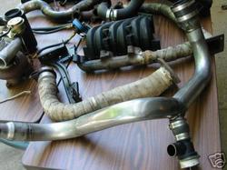 1992 Ford Probe - A collection of turbocharger and exhaust manifold components are displayed on a table.