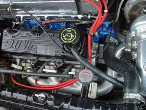 1992 Ford Probe - Close-up view of a modified V6 engine, showing custom blue components and red wiring.
