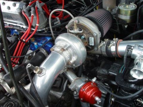 1992 Ford Probe - A close-up view of a modified engine bay a turbocharger and associated plumbing.