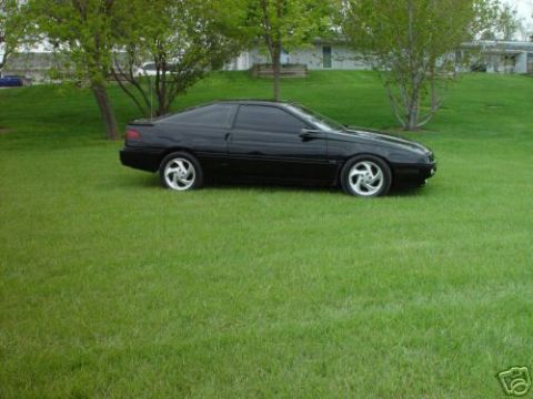 1992 Ford Probe - A black 1992 Ford Probe is shown from the side, parked on a green lawn.