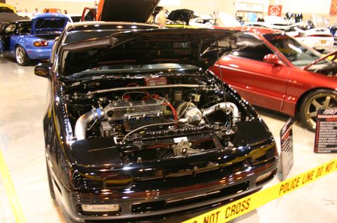 1992 Ford Probe - A black sports car with its hood open is displayed, with other vehicles and yellow caution tape visible.