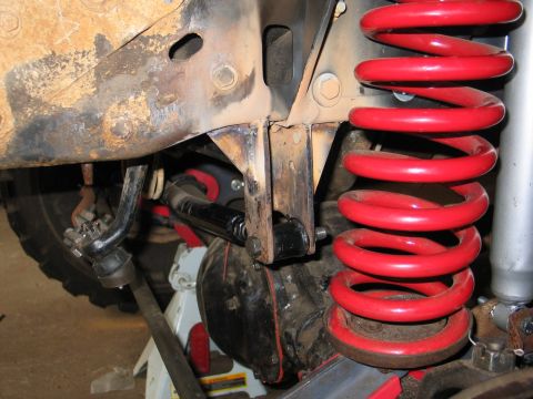 1995 Ford Bronco - Vehicle suspension components, including a red coil spring and linkage, are visible in this close-up shot.