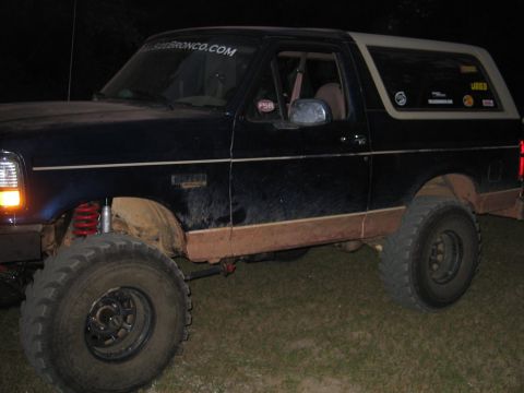 1995 Ford Bronco - Side view of a lifted 1995 Ford Bronco with off-road tires and custom windshield sticker.