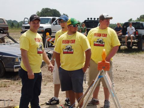 2000 Chevrolet Tahoe - Men in matching t-shirts stand together outdoors with several vehicles visible behind them.