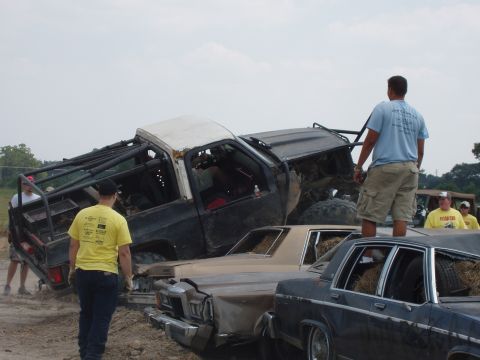 2000 Chevrolet Tahoe - Multiple vehicles are involved in a demolition derby or similar event, with one truck on top of a sedan.