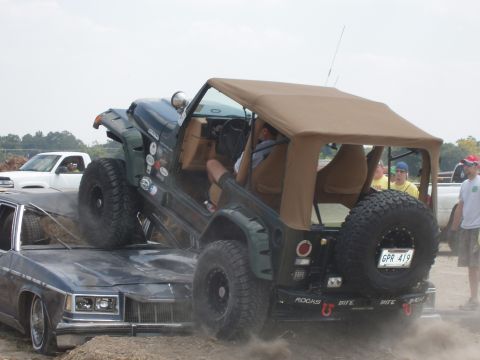 2000 Chevrolet Tahoe - A Jeep Wrangler is shown crushing a sedan during an off-road event.