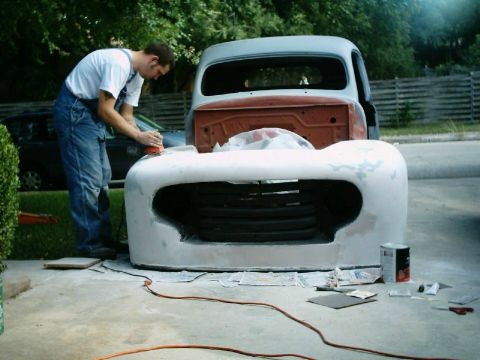 1972 Ford Ranchero - A person is sanding the front end of a classic truck that appears to be undergoing restoration.