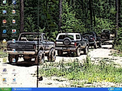 1993 Ford Bronco - Multiple Ford Broncos and F-Series trucks drive on a dirt path through a forest.