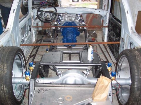 1979 Ford Bronco - The interior of a vehicle undergoing extensive modifications, with the engine and drivetrain exposed.