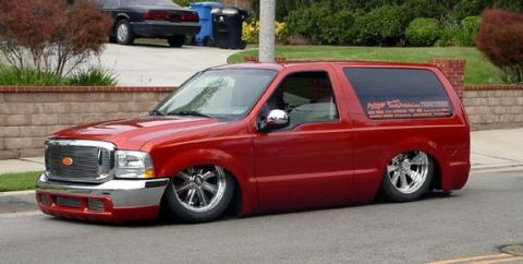 1979 Ford Bronco - This red SUV features custom chrome wheels and a significantly lowered suspension, giving it a unique, ground-hugging stance.