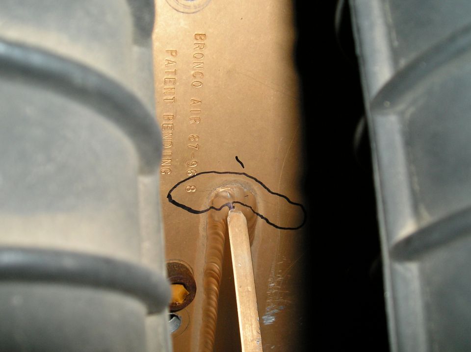 Bracket stamped BRONCO AIR 87-96 with a damaged spot circled in marker