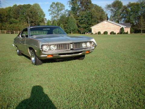 1971 Ford Torino - A silver 1970 Ford Torino is parked on a grassy lawn with a brick house in the background.