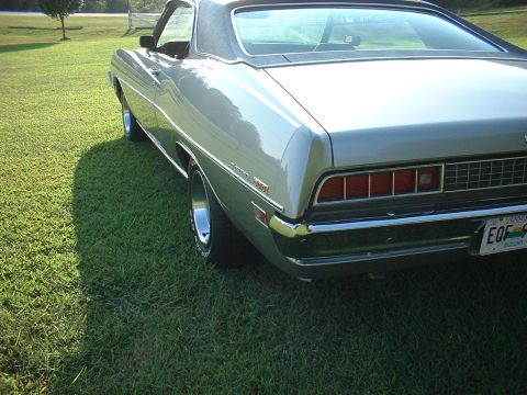 1971 Ford Torino - Rear view of a silver car with a black vinyl roof, parked on a grassy lawn.