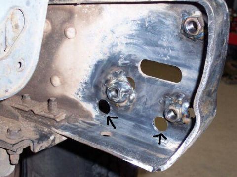 1991 Ford Bronco - Metal frame bracket with welded nuts and bolts, showing two holes marked with arrows.