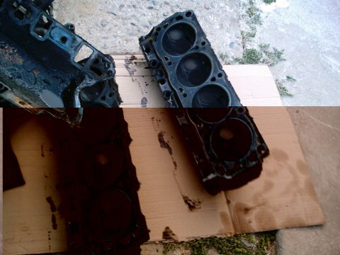 1986 Ford Bronco - Two greasy V8 cylinder heads pulled from an engine and laid combustion-chamber-up on flattened cardboard outside on a concrete driveway. Th…