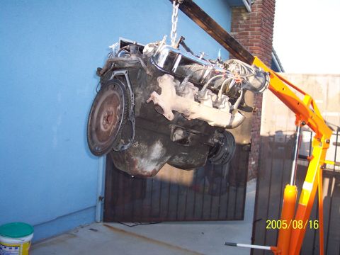 1985 Ford Bronco - Engine hoist lifting a vehicle engine outdoors. Date stamp visible on the hoist.