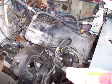 1985 Ford Bronco - Close-up view of an engine bay, focusing on the AC compressor and associated plumbing. A date stamp indicates the photo was taken on August…