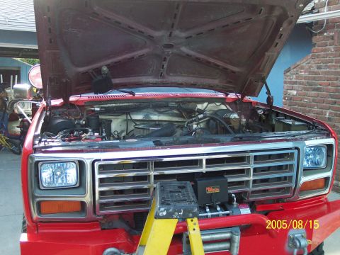1985 Ford Bronco - Front view of a red Ford truck with the hood open, revealing the engine compartment and a winch.