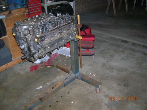 1985 Ford Bronco - Engine on a stand in a garage setting, with tools and red toolboxes in the background.