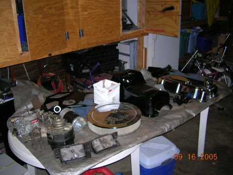 1985 Ford Bronco - Various engine components are spread across a table, ready for assembly or repair.