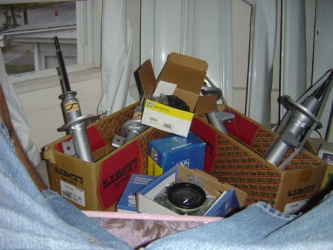 1998 Ford Taurus - Various automotive parts are organized in cardboard boxes, ready for installation.