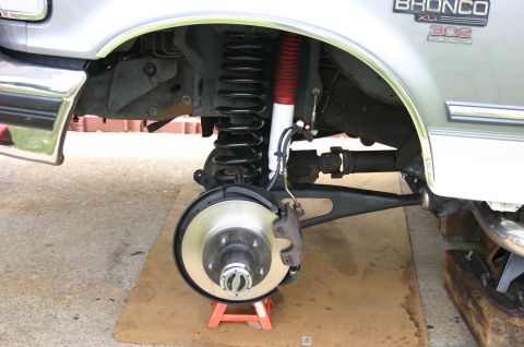 1994 Ford Bronco - The front suspension of a 1994 Ford Bronco is shown with a lift kit installed, a red and white shock absorber.