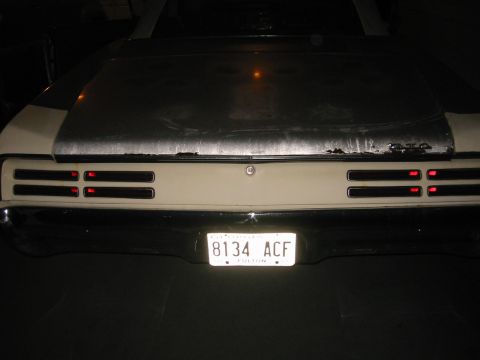 1967 Pontiac GTO - The rear of a 1967 Pontiac GTO shows its distinctive horizontal taillight arrangement and a license plate.