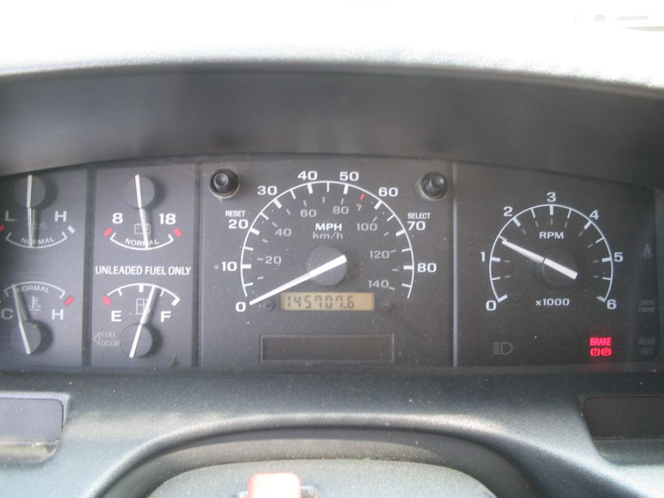 Dashboard gauges showing fuel, oil pressure, speed, and RPM. Odometer reads 145707.6