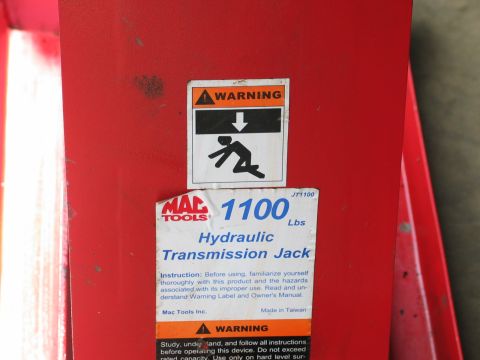 1995 Ford Bronco - Mac Tools hydraulic transmission jack, model JT1100, with a 1100 lbs capacity.